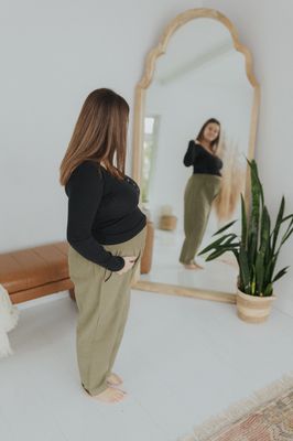a woman standing in front of a mirror