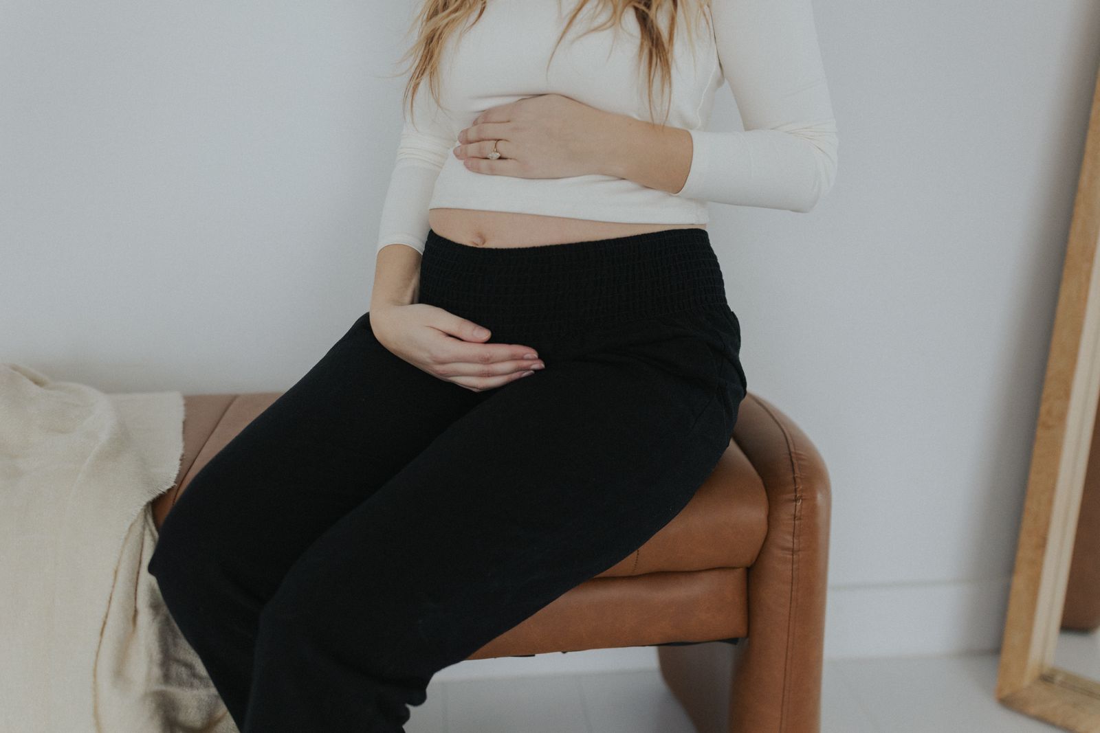 a pregnant woman sitting on a leather chair
