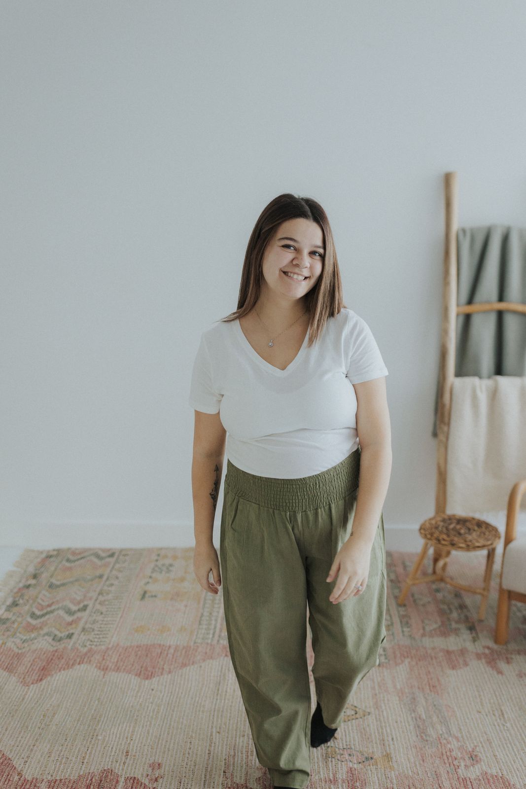 a woman standing on a rug in front of a chair