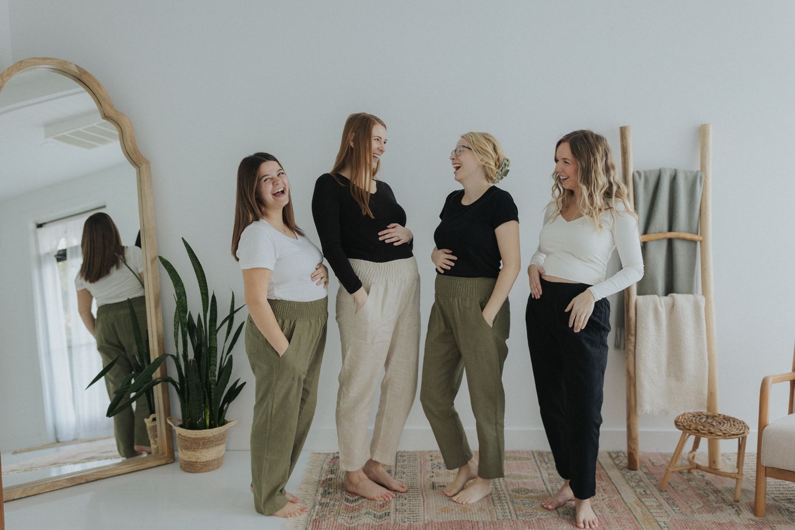a group of women standing next to each other in front of a mirror