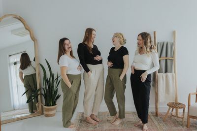 a group of women standing next to each other in front of a mirror