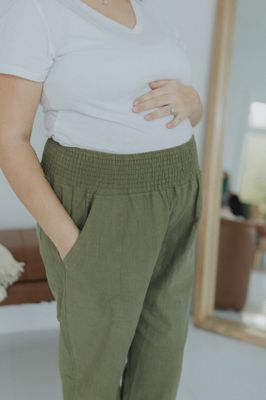 a woman in a white shirt and green pants