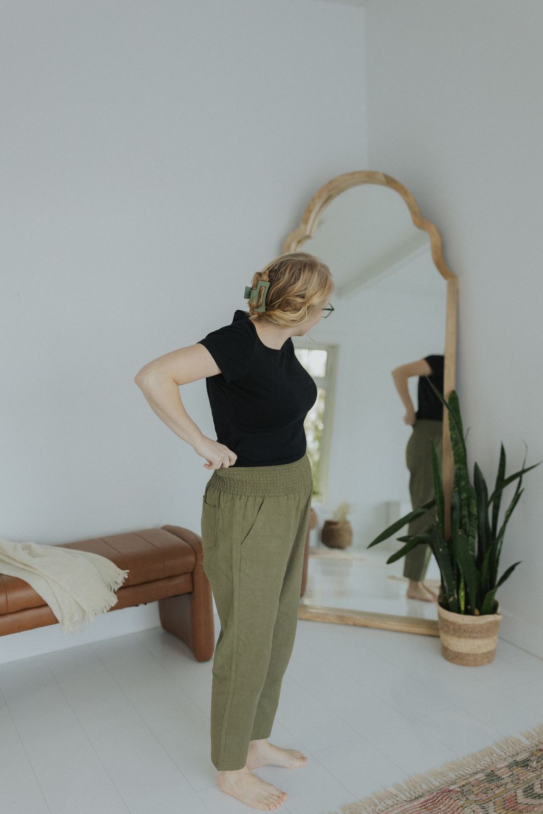 a woman standing in front of a mirror in a room