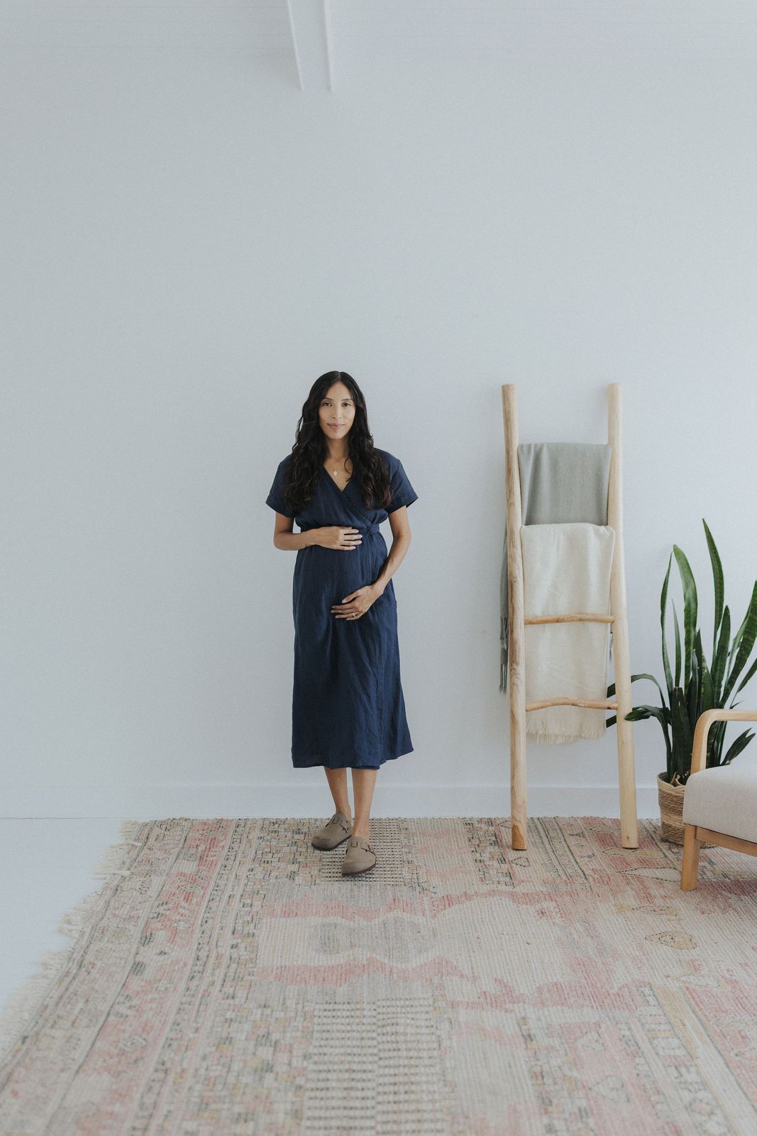 a woman standing in front of a white wall