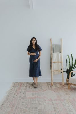 a woman standing in front of a white wall