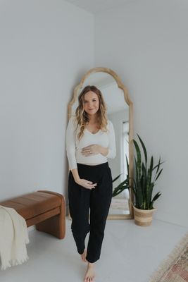 a pregnant woman standing in front of a mirror