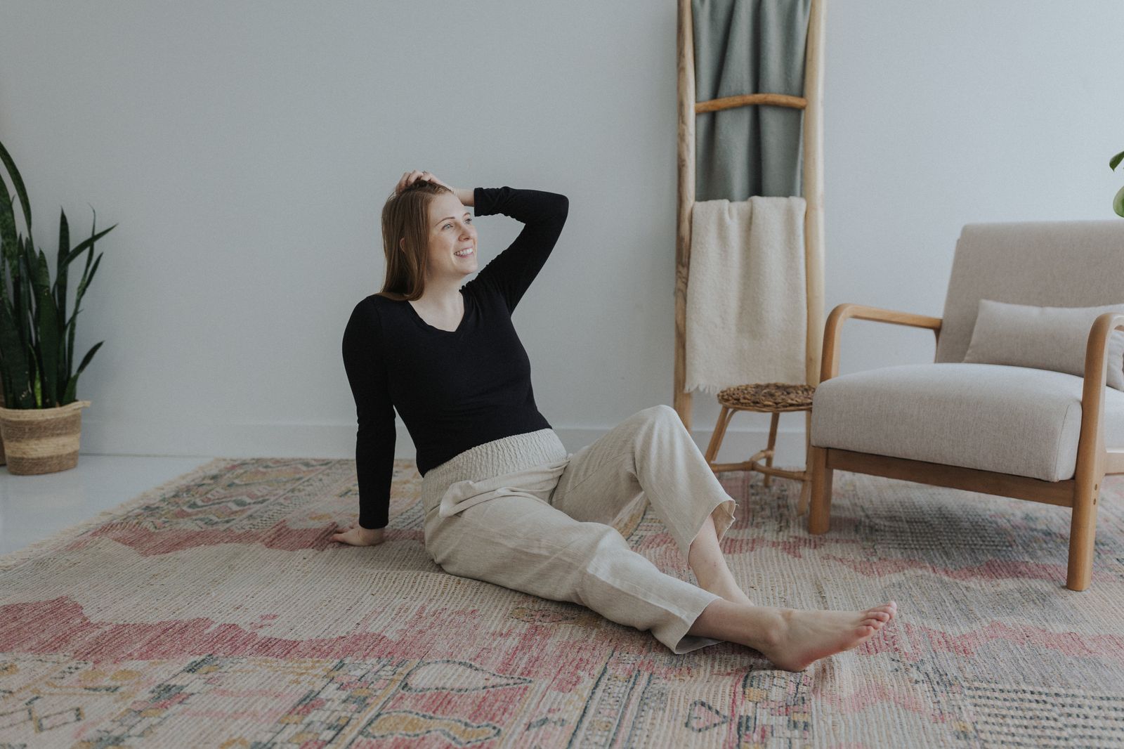 a woman sitting on a rug in a room