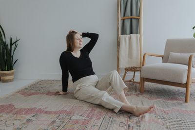 a woman sitting on a rug in a room
