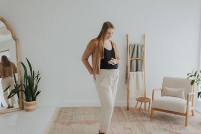 a woman standing in front of a mirror in a room