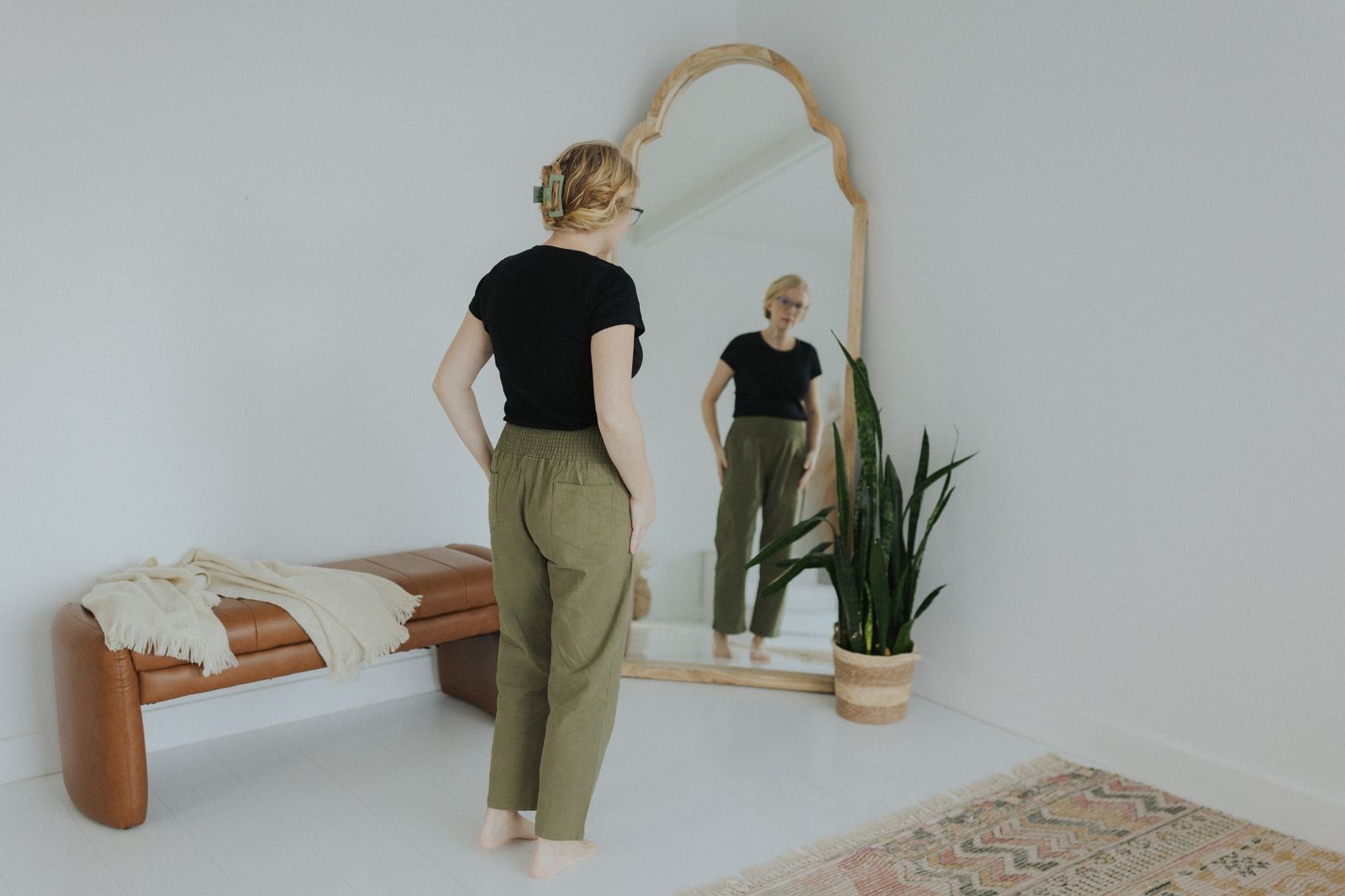 a woman standing in front of a mirror in a room