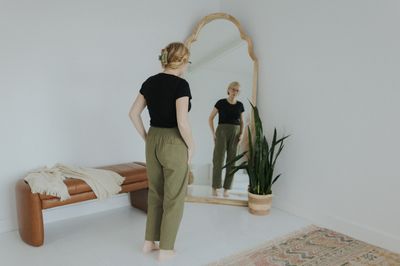 a woman standing in front of a mirror in a room