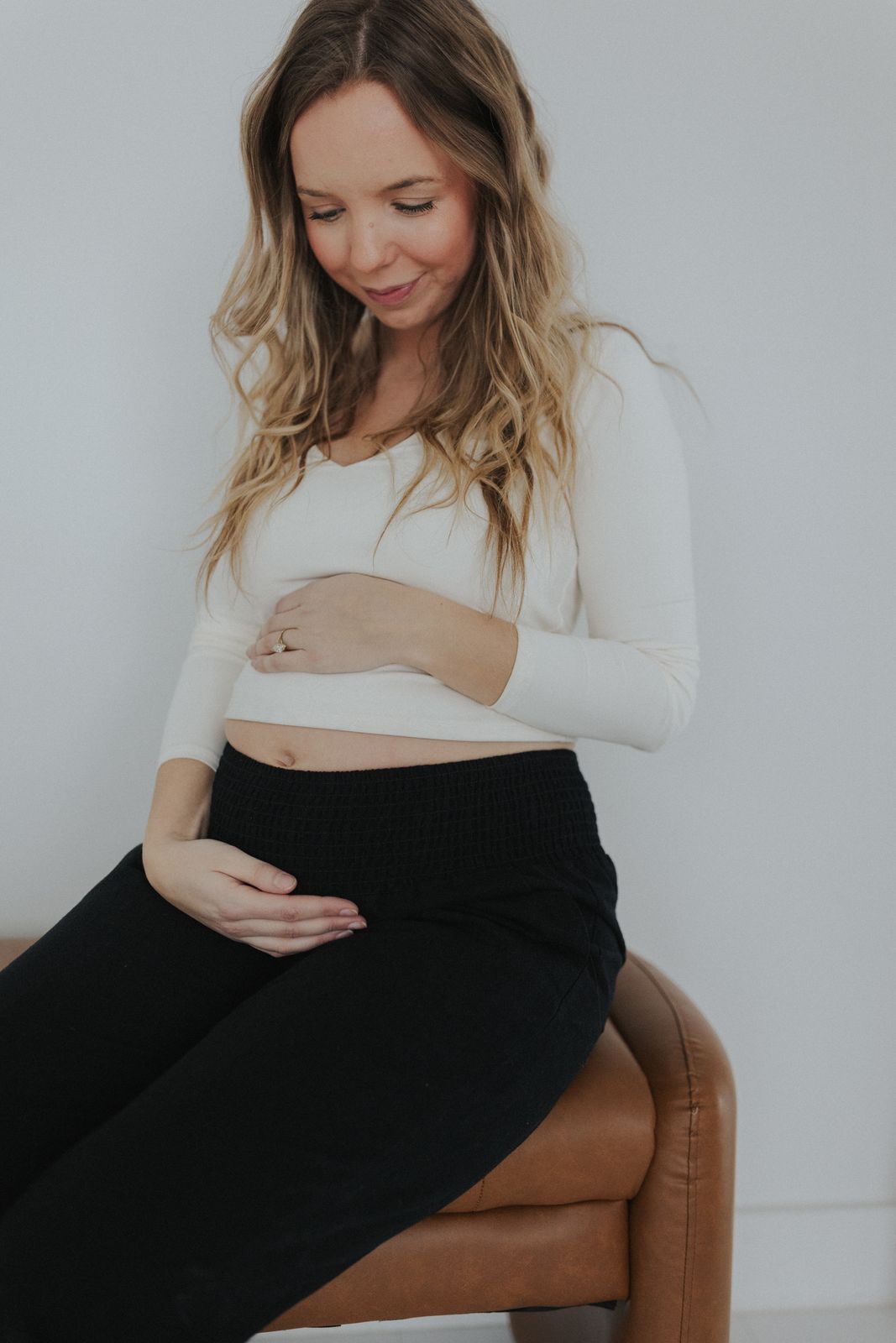 a pregnant woman sitting on a brown chair