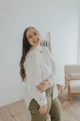 a smiling woman in a white shirt and khaki pants