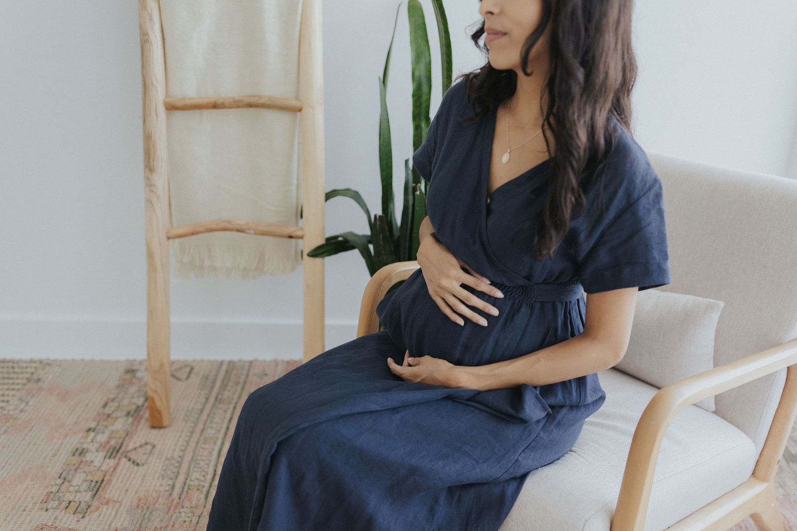 a pregnant woman sitting on a chair in a room