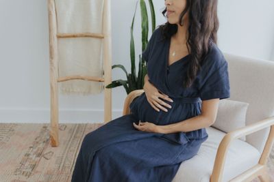 a pregnant woman sitting on a chair in a room