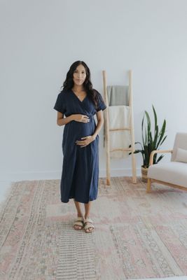 a pregnant woman standing on a rug in a room