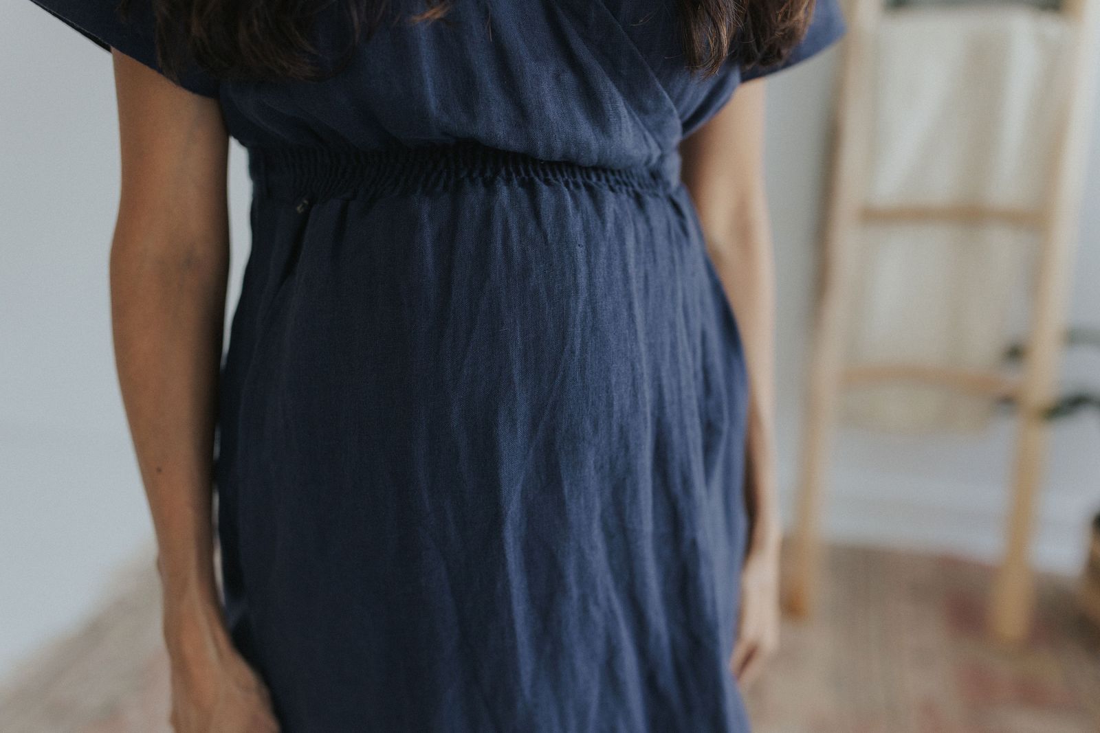 a woman in a blue dress standing in a room