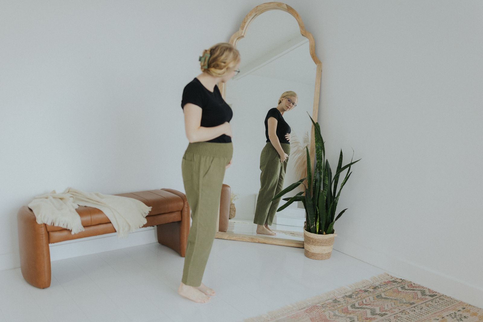 a woman standing in front of a mirror in a room