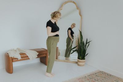 a woman standing in front of a mirror in a room