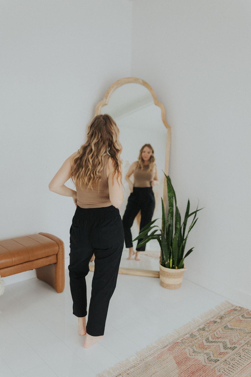 a woman standing in front of a mirror