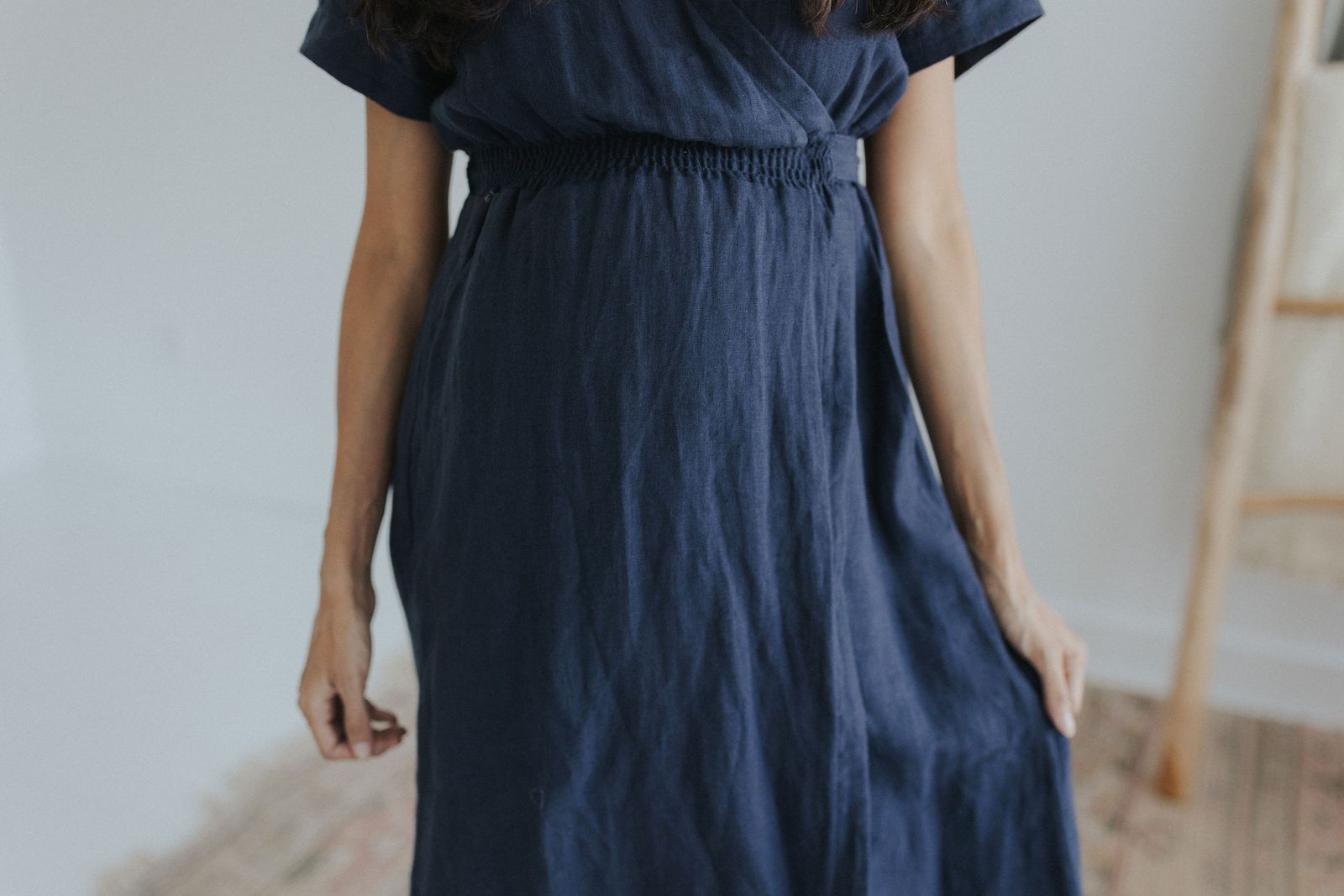 a woman standing in a room wearing a blue dress