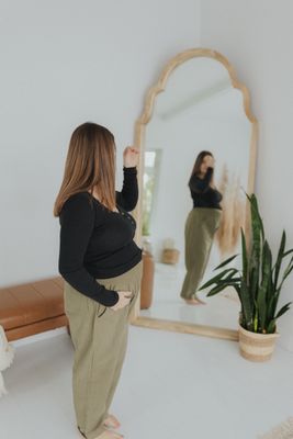 a woman standing in front of a mirror