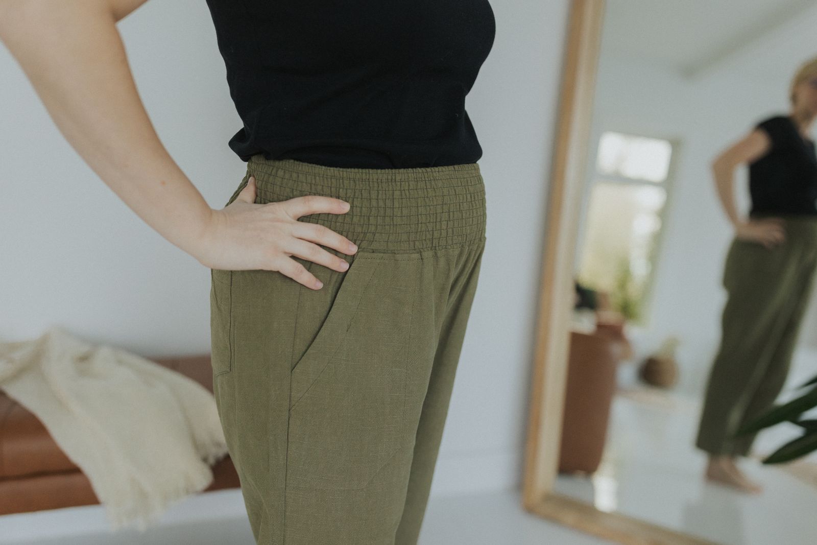 a woman standing in front of a mirror with her hands on her hips
