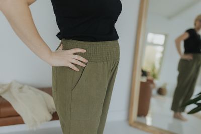 a woman standing in front of a mirror with her hands on her hips