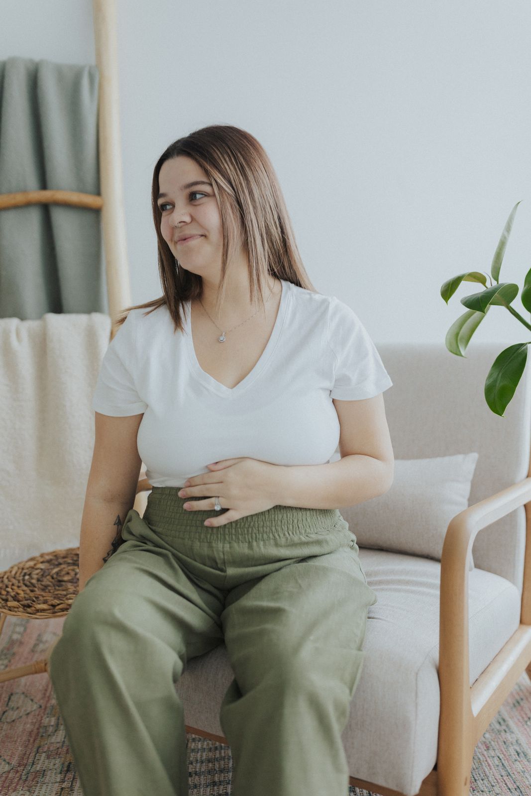 a woman sitting in a chair with her stomach exposed