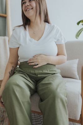 a woman sitting on a couch with her stomach exposed
