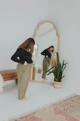 a woman standing in front of a mirror