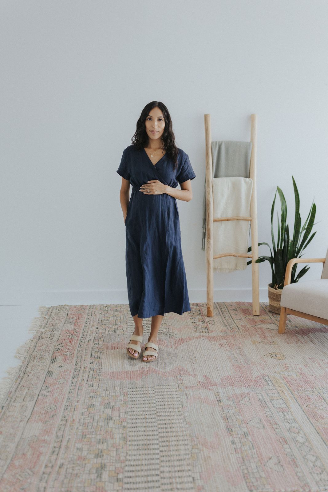 a woman standing in front of a white wall