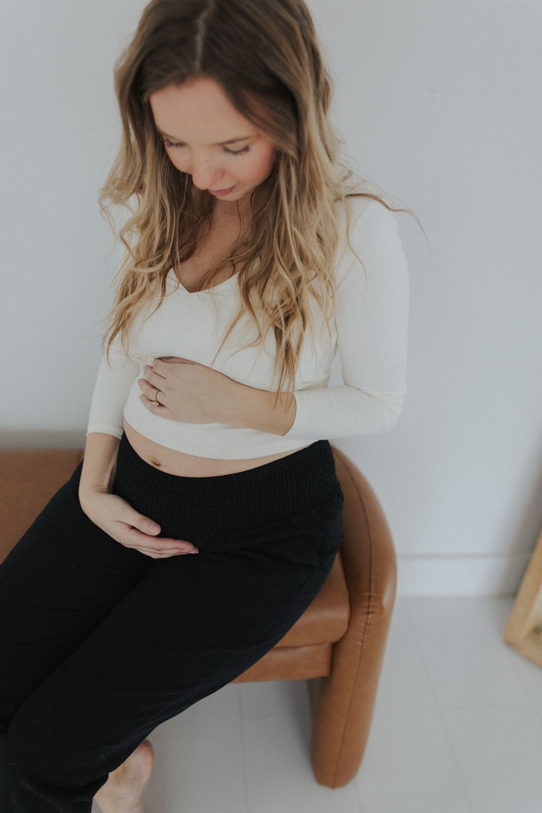 a pregnant woman sitting on a chair with her stomach exposed