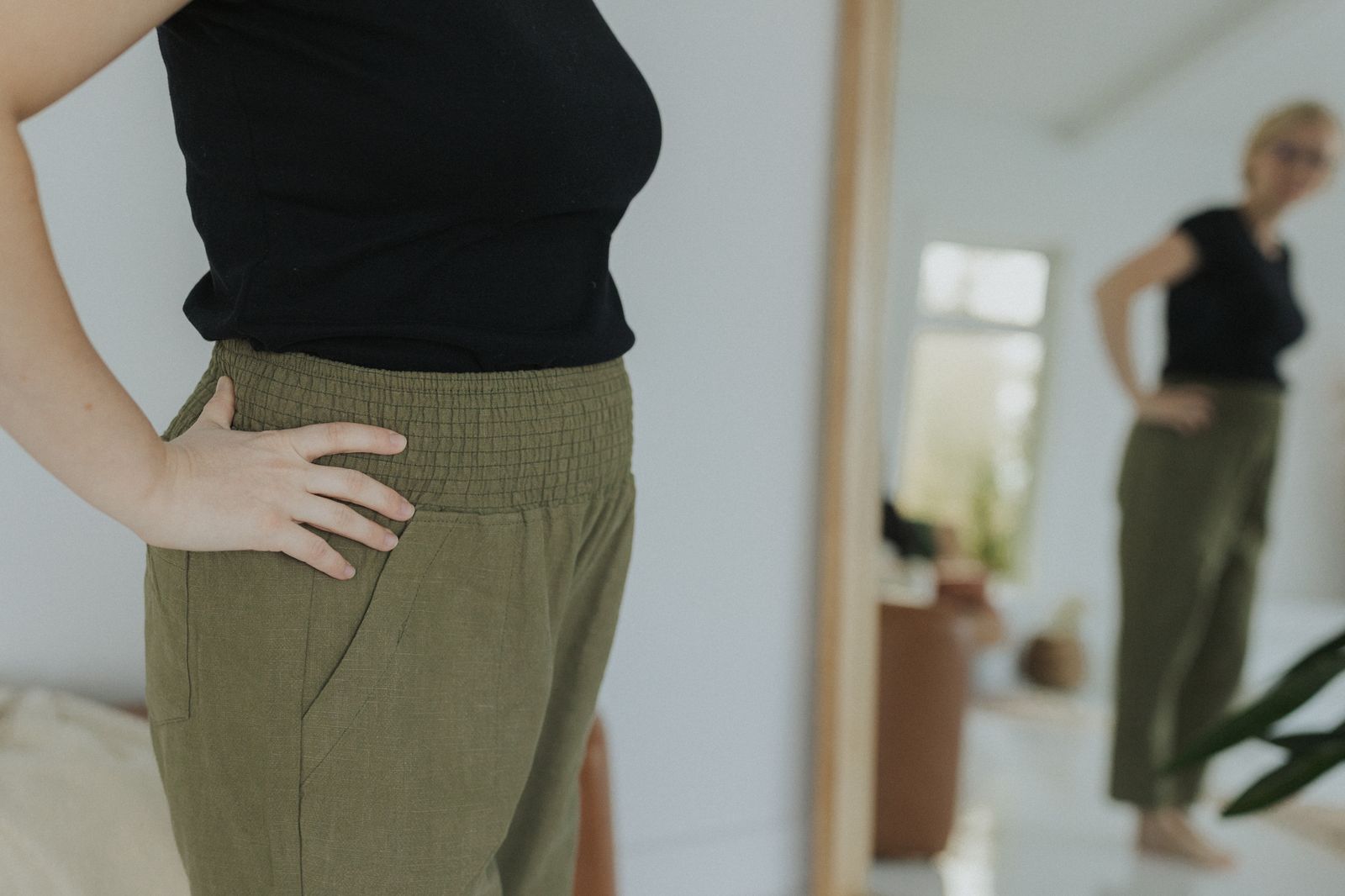 a woman standing in front of a mirror with her hands on her hips