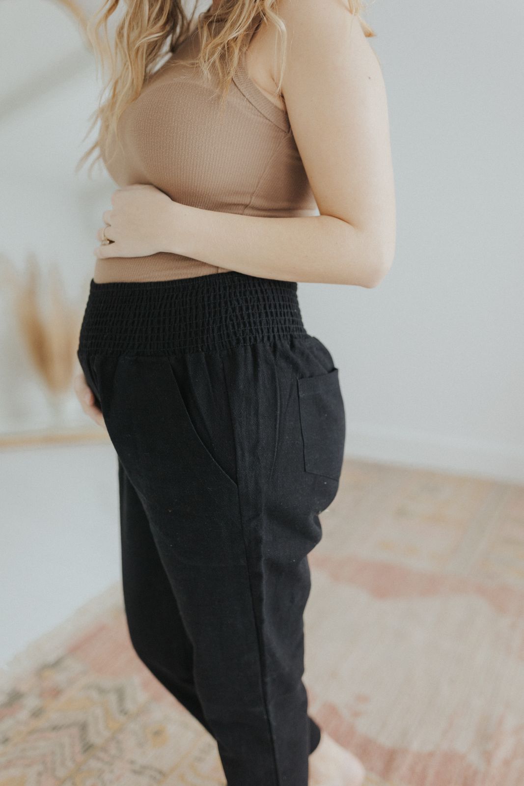 a woman standing on a rug with her arms crossed
