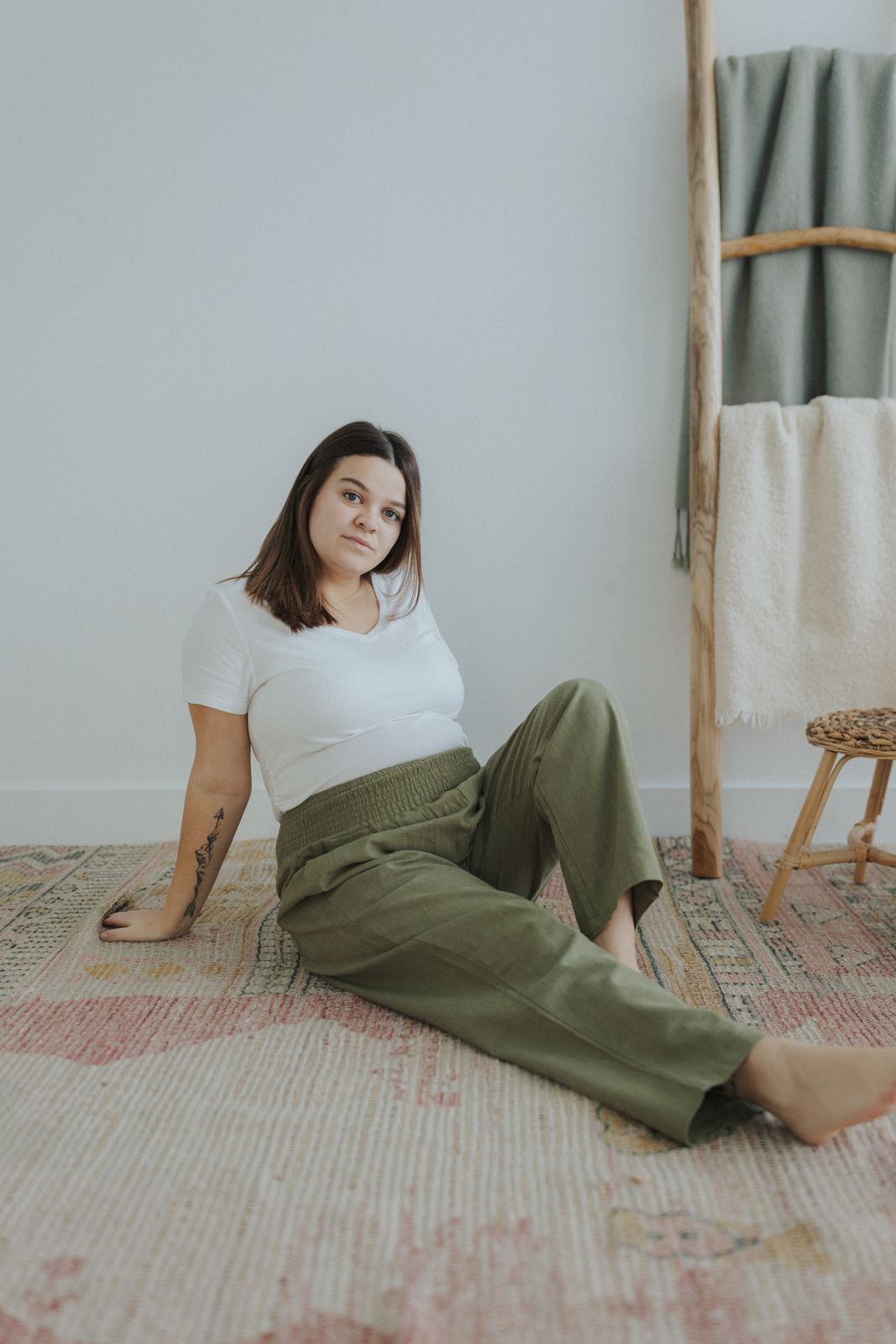 a woman sitting on the floor with her legs crossed