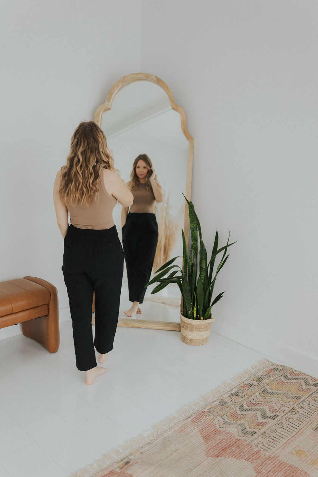a woman standing in front of a mirror