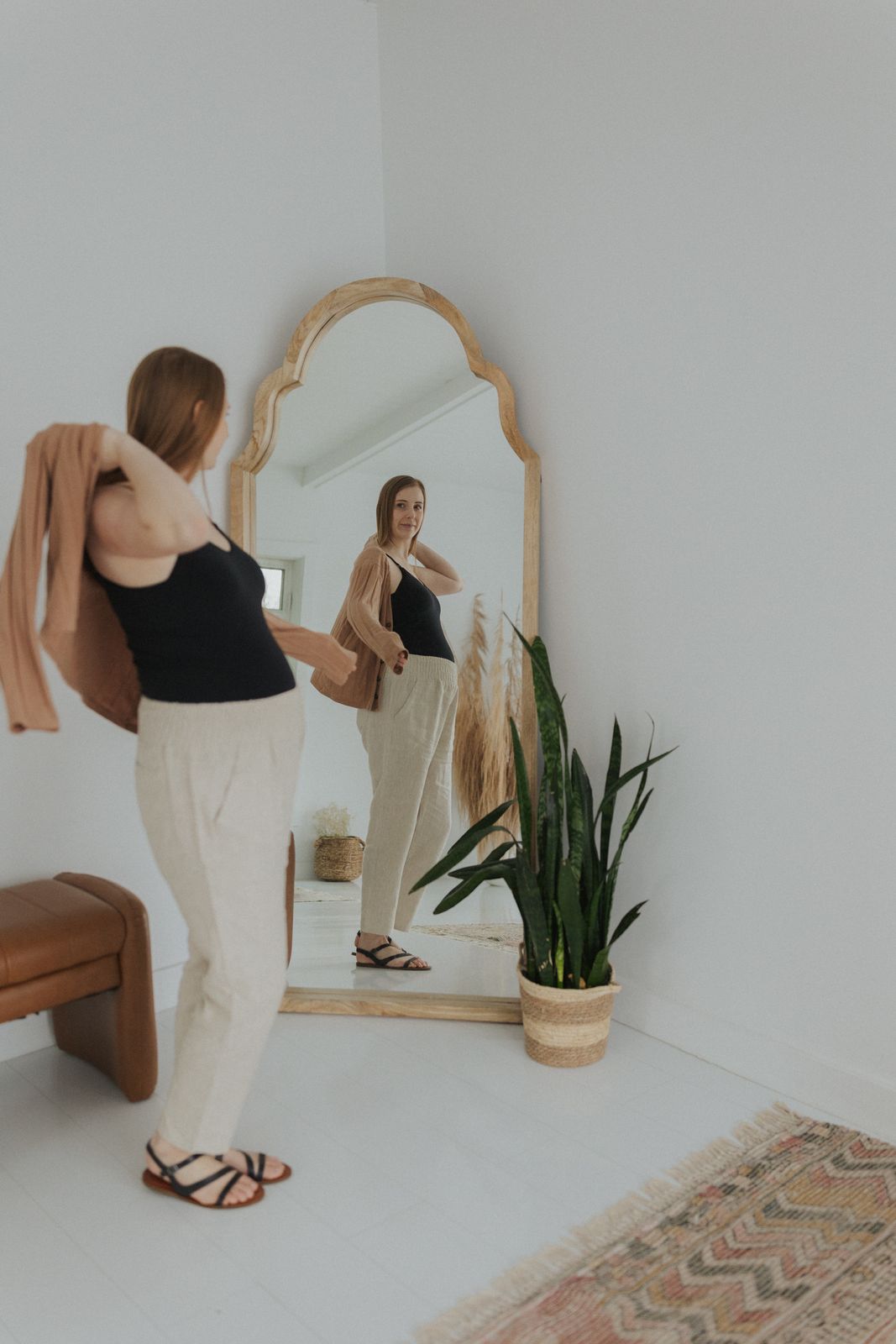 a woman standing in front of a mirror