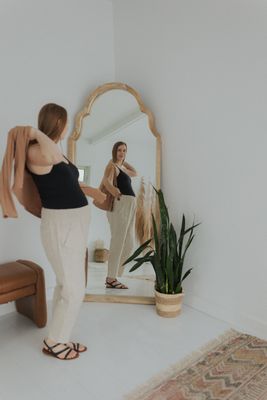 a woman standing in front of a mirror