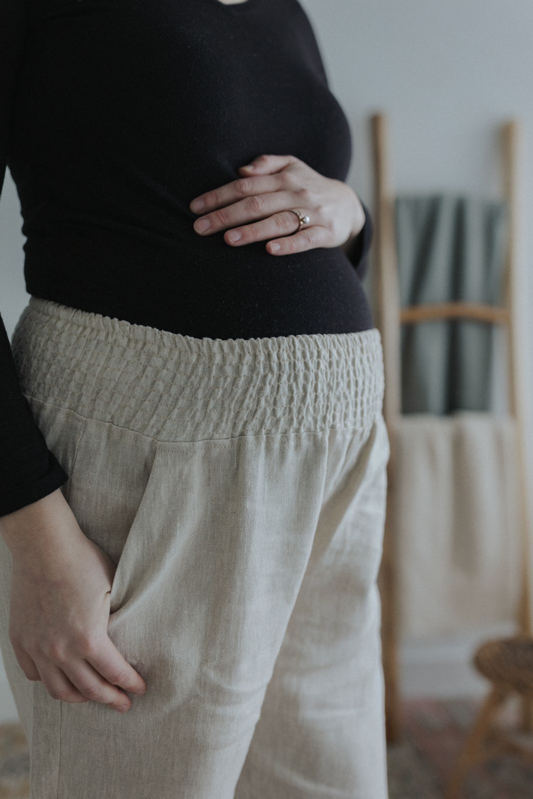 a pregnant woman standing in front of a chair