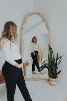 a woman standing in front of a mirror