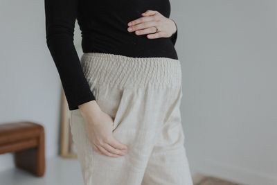 a woman wearing a black top and beige pants