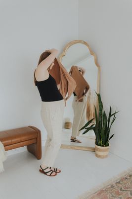a woman standing in front of a mirror
