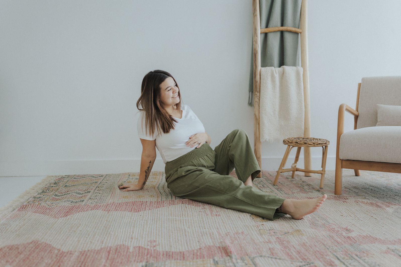 a woman sitting on a rug in a room
