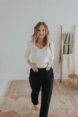 a woman standing in front of a white wall