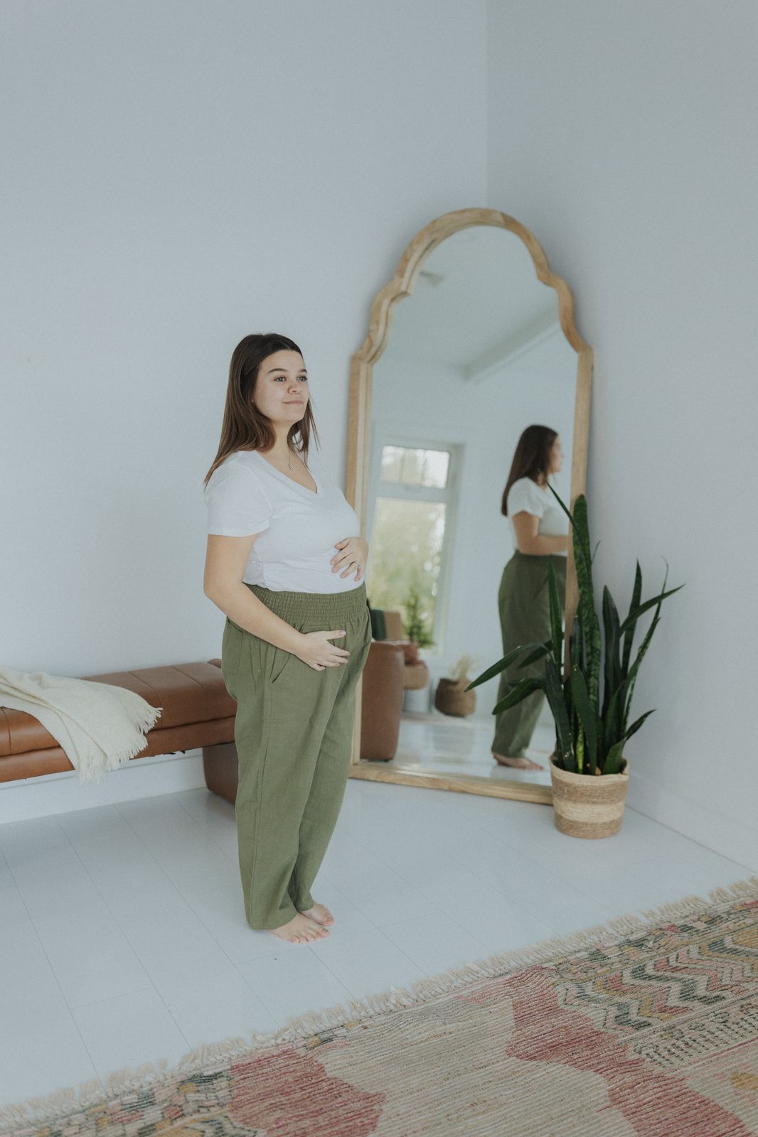 a pregnant woman standing in front of a mirror