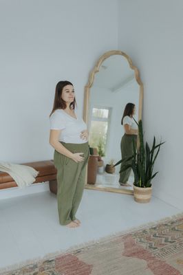 a pregnant woman standing in front of a mirror
