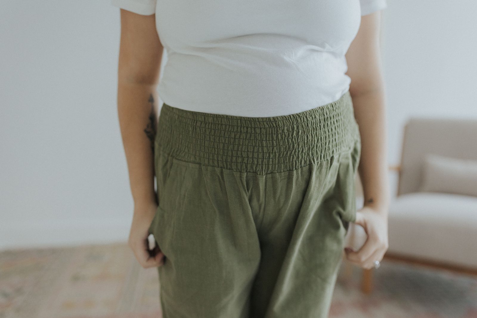 a woman in a white shirt and green pants