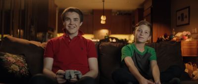 two people sitting on a couch playing a video game