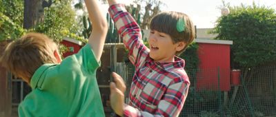 a boy and a girl playing in a backyard